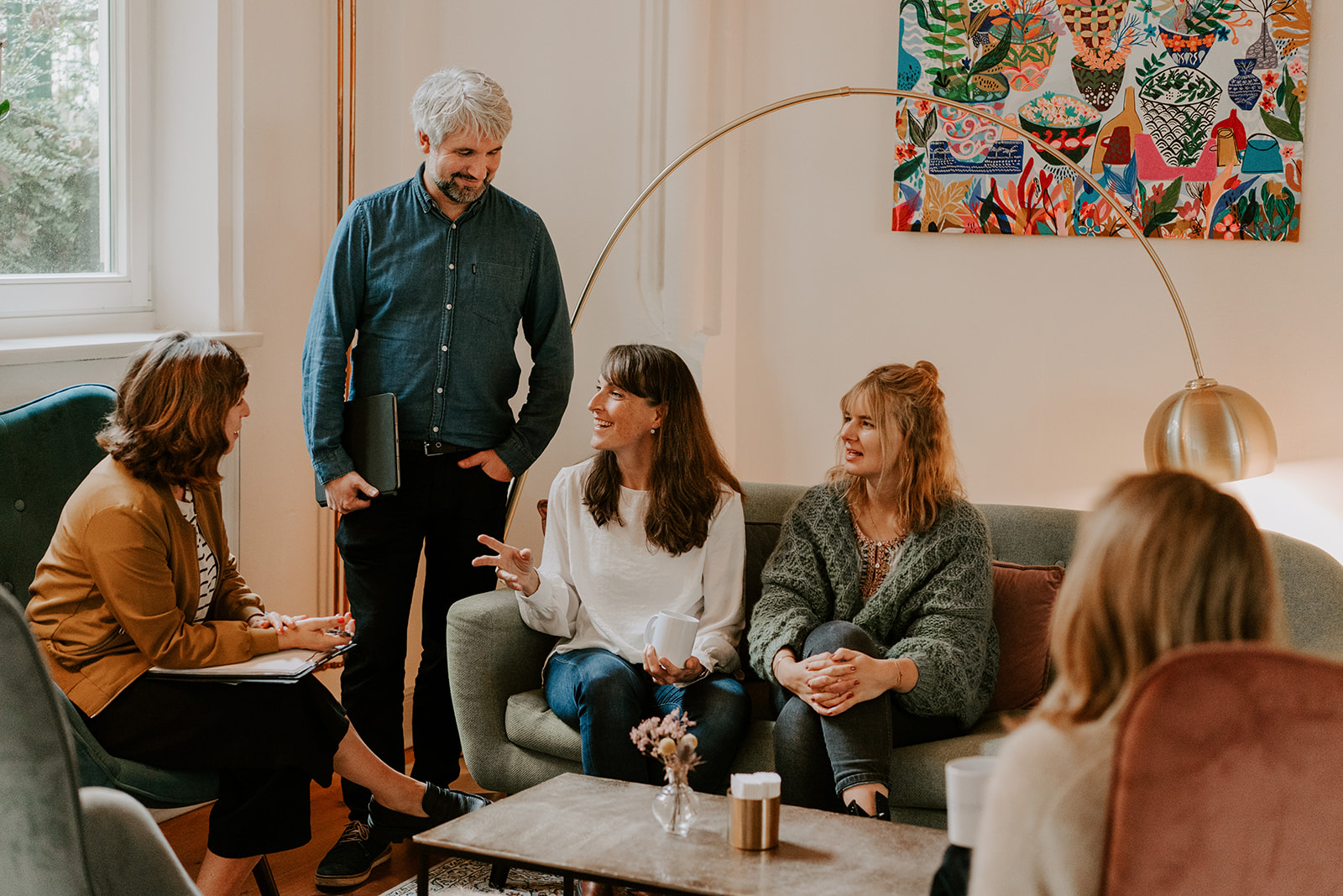 verschiedene Therapeutinnen aus dem Team Eimsbüttel sitzen in einer Sitzgruppe im Gespräch